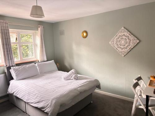 a bedroom with a bed with white sheets and a window at 51 Lenham House in Sutton
