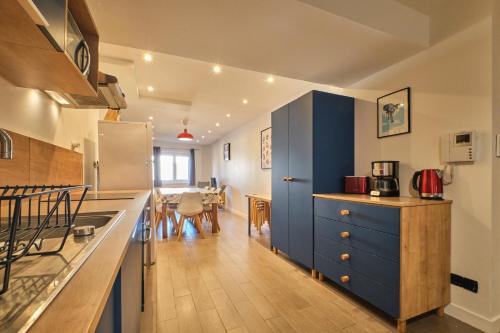 une cuisine avec des armoires bleues et une salle à manger dans l'établissement Marmotte 206, à Les Deux Alpes