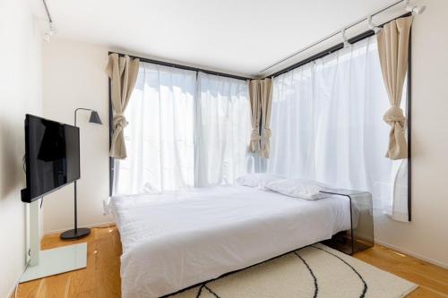 a bedroom with a bed and a large window at trias527 4-3 in Tokyo