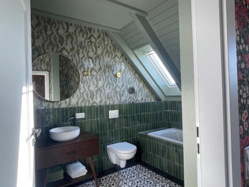 a bathroom with a sink and a toilet and a tub at Alwine - Landhaus an den Spreewiesen in Rietz Neuendorf