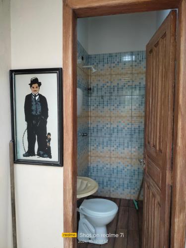 a bathroom with a toilet and a picture of a man at Cantinho da Paz in Serra Grande