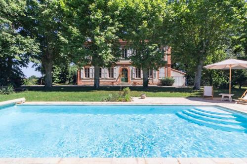 une piscine devant une maison dans l'établissement Demeure Bajou - piscine privée - parc arboré, à Auterive