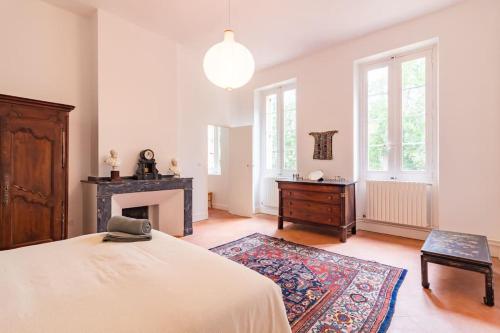 - une grande chambre avec un lit et une cheminée dans l'établissement Demeure Bajou - piscine privée - parc arboré, à Auterive