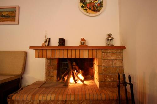 a brick fireplace with a fire in it at 7hills Waterfall Lodge by Ski Alure in Eptalofos