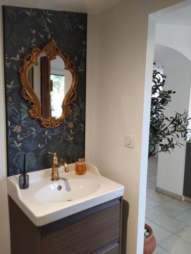 une salle de bain avec un lavabo et un miroir sur un mur dans l'établissement Plaisirs cachés - Love Room -, à La Garde