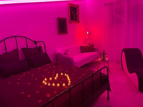 - une chambre avec un lit dans une chambre rose dans l'établissement Plaisirs cachés - Love Room -, à La Garde