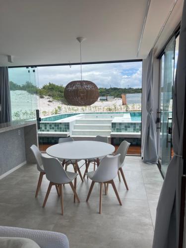 un tavolo con sedie in una camera con vista sulla spiaggia di Casa Costa do Sauipe- Dentro do Complexo - Reserva sauipe a Mata de Sao Joao