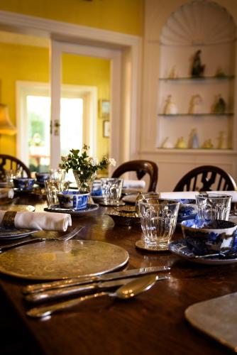 a wooden table with plates and glasses on it at Barnard House in Great Yarmouth