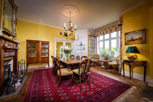 a dining room with a table and a red rug at Barnard House in Great Yarmouth