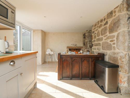 a kitchen with a counter and a stone wall at Bal View in Lower Boscaswell