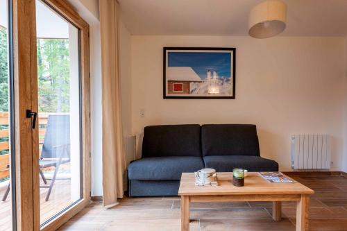 a living room with a couch and a table at Résidence Arya - Living Stone in Vars