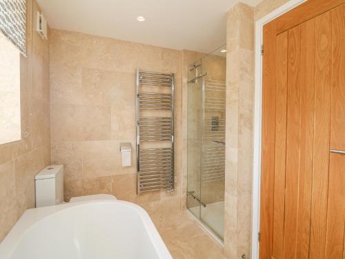 a bathroom with a toilet and a glass shower at Bal View in Lower Boscaswell