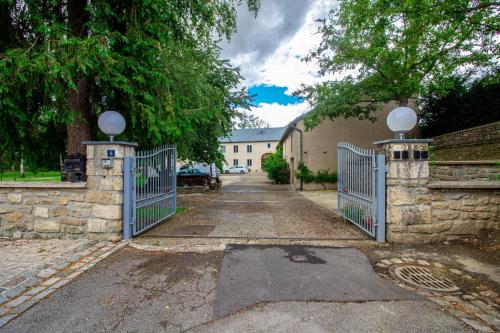 a gate to a driveway with a stone wall at Sweet-mane in Roeser