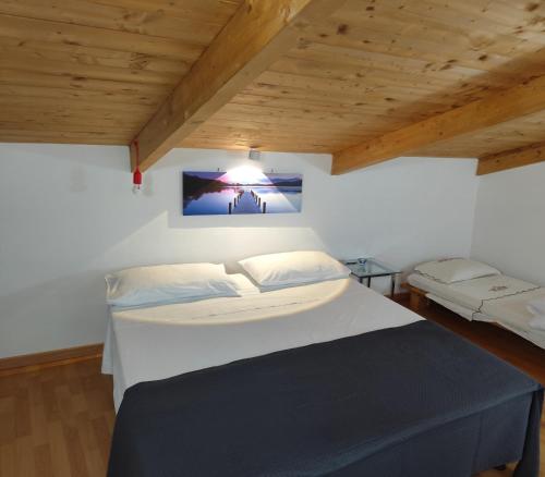 a bedroom with a large white bed and wooden ceilings at BeB Silvia in Santa Maria Capua Vetere