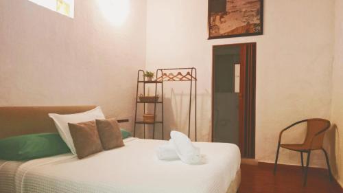 a bedroom with a white bed and a chair at Lotus Central Hotel in Santa Marta