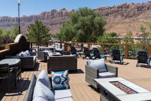 a patio with chairs and tables and mountains in the background at Desert Glamping Getaway Near Moab Arches NP in Moab