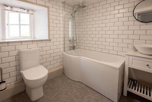 a white bathroom with a toilet and a sink at Rhubarb Cottage in Chapel Stile