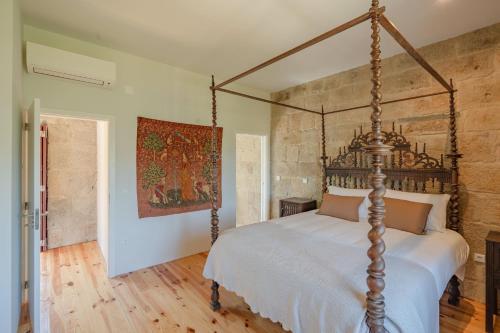 a bedroom with a canopy bed in a room at Feel Discovery Casa da Granja Douro Valley in Resende