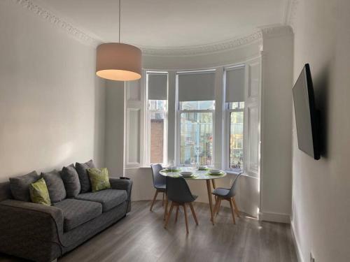 a living room with a couch and a table at 3 Smithhills Paisley central spacious sleeps 4 in Paisley