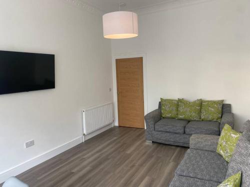 a living room with a couch and a flat screen tv at 3 Smithhills Paisley central spacious sleeps 4 in Paisley