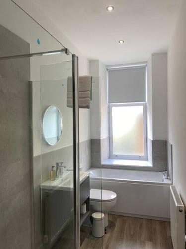 a bathroom with a toilet and a sink and a window at 3 Smithhills Paisley central spacious sleeps 4 in Paisley