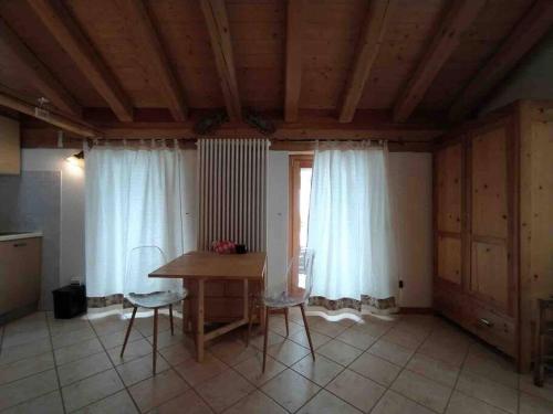 a kitchen with a table and chairs in a room at LA VOCE DEL BOSCO Selva di Cadore in Selva di Cadore