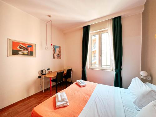 a hotel room with a bed and a table and a window at Ostello Bello Milano Centrale in Milan