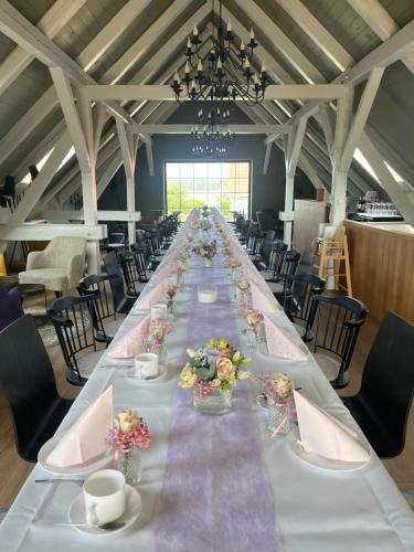 a long long table in a large room with chairs at Alwine - Landhaus an den Spreewiesen in Rietz Neuendorf