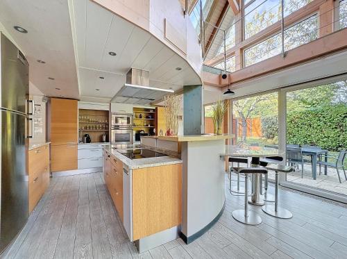 une grande cuisine avec une grande fenêtre et une table dans l'établissement Le Domaine de la Chapelle, à Osenbach