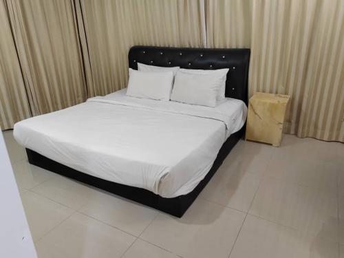 a bed with white sheets and pillows in a room at Kl Continew Suite At Times Square in Kuala Lumpur