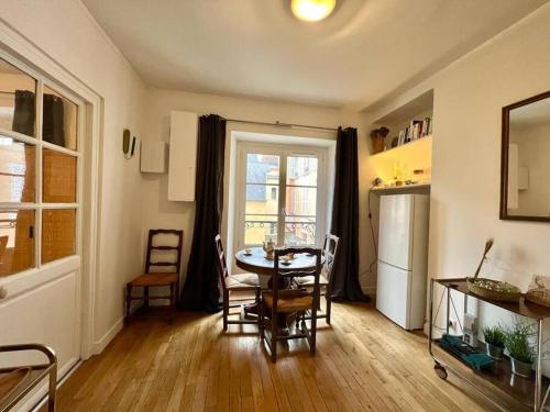 une cuisine et une salle à manger avec une table et un réfrigérateur dans l'établissement Jardins de Versailles - Le Mythique - 16C, à Versailles