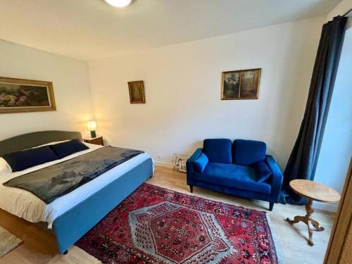une chambre avec un lit bleu et une chaise bleue dans l'établissement Jardins de Versailles - Le Mythique - 16C, à Versailles
