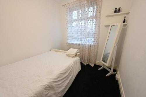 a bedroom with a bed and a mirror and a window at Grainger park in Newcastle upon Tyne