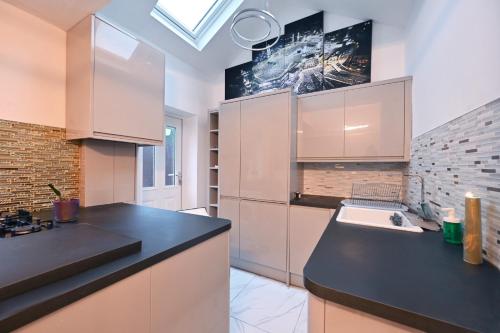 a kitchen with white cabinets and a black counter top at Grainger park in Newcastle upon Tyne