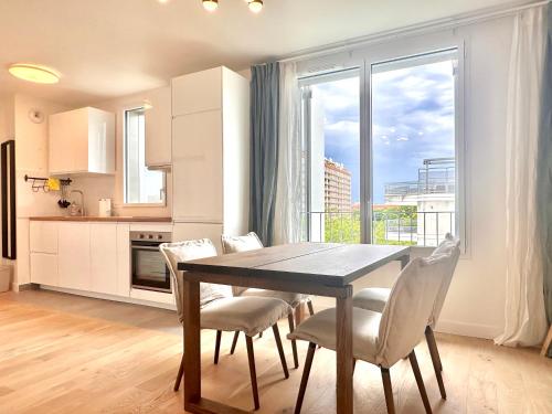 une cuisine et une salle à manger avec une table et des chaises dans l'établissement Home in Poniatowski near Vincennes Forest, à Paris