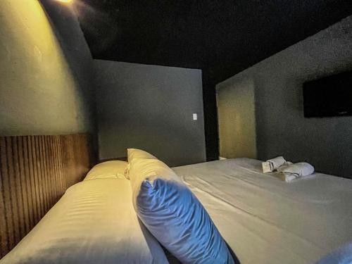 a bedroom with two beds and a blue pillow at Antonia Poolside Autonomy Hotel in Ibagué