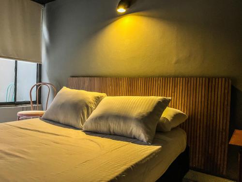 a bed with two pillows on top of it at Antonia Poolside Autonomy Hotel in Ibagué