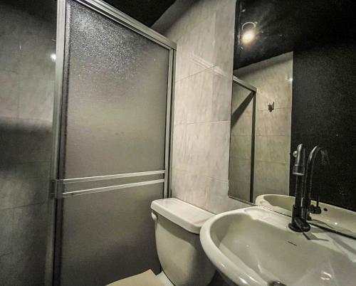 a bathroom with a shower and a toilet and a sink at Antonia Poolside Autonomy Hotel in Ibagué