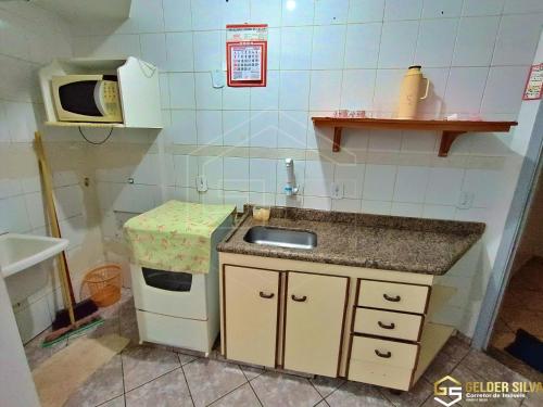 a small kitchen with a sink and a microwave at Golden Thermas Residence Torre B e C anexo ao CTC in Caldas Novas