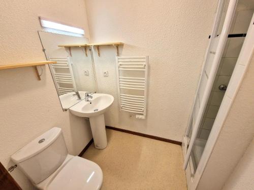une salle de bain avec toilettes, lavabo et miroir dans l'établissement Charmant appartement pour 8 pers avec équipements modernes à Valfréjus - FR-1-265-167, à Valfréjus