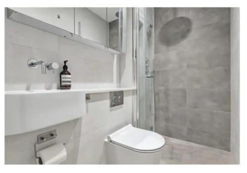 a white bathroom with a toilet and a shower at Richmond Maisonette 3 bed, 2 bath & garden terrace in Richmond