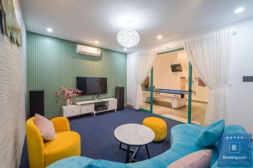 a living room with a couch and a tv at Kim Villa 45 - Cách Bãi Tắm 100 Met - Full Máy Lạnh Các Phòng - Bida - Phòng Karaoke - Siêu Gần Biển in Vung Tau