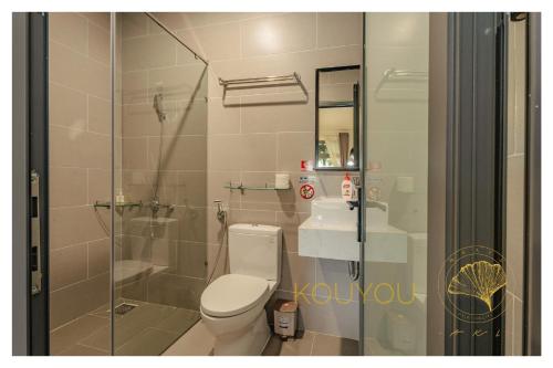 a bathroom with a toilet and a glass shower at Aki 秋 Hostel in Da Lat