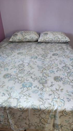 a bed with a blanket and two pillows on it at Casa mobiliada privativa in Caiçara