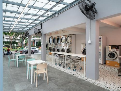 a room with tables and chairs and washing machines at Wash House Chatuchak in Bangkok