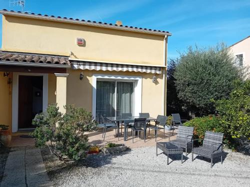 a patio with a table and chairs in front of a house at Villa la Farigoulo in Juan-les-Pins