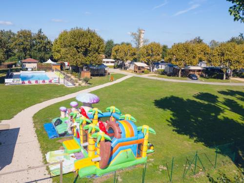 a playground in a park with a play equipment at L'Oasis des Dombes in Ambérieux-en-Dombes