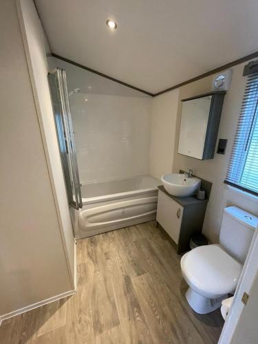 a bathroom with a shower and a toilet and a sink at Golden Palm Resort - The Atlas Family - Coastal Caravan Breaks in Chapel Saint Leonards