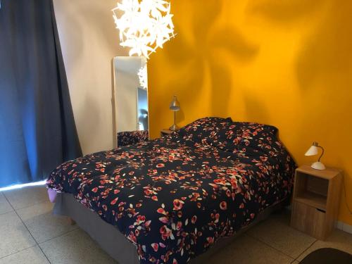 - une chambre avec un lit, un miroir et un lustre dans l'établissement Soleil de mai, à Marseille