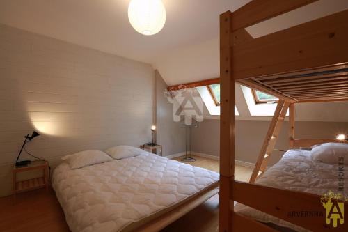 1 Schlafzimmer mit 2 Etagenbetten und einer Lampe in der Unterkunft Rev'O'Lac 2 in Chambon-sur-Lac